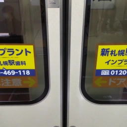 「新札幌駅歯科」の看板（ドアステッカー）