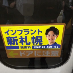 インプラント新札幌駅歯科の文字・顔写真が載ったステッカー