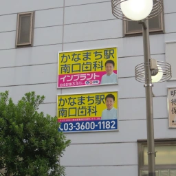 かなまち駅南口歯科の看板が縦に2枚並んでいる